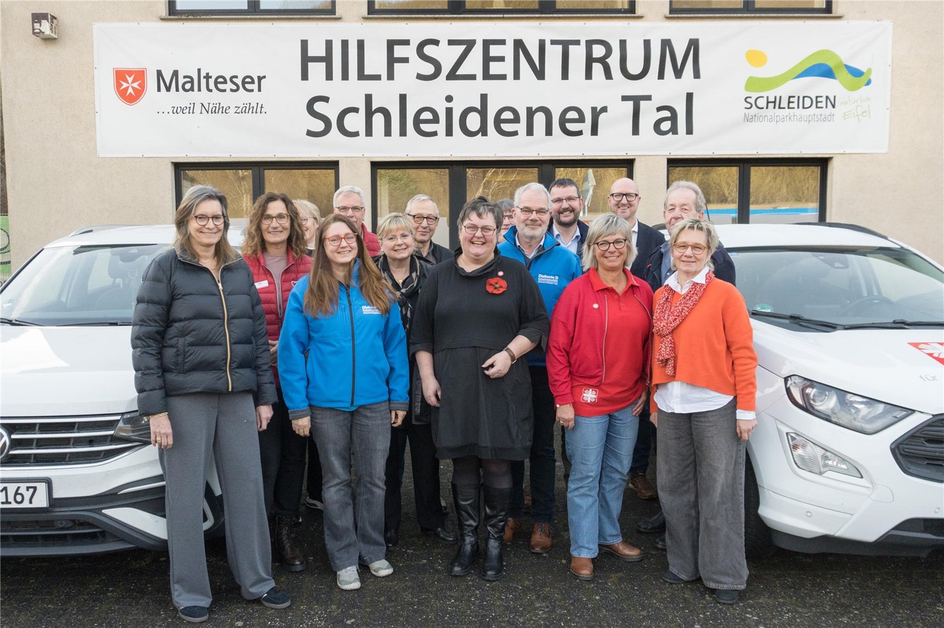 Gruppenfoto aller Akteure vor dem Zentrumsgebäude. Im Hintergrund auf der Wand hängt noch das große Schild "Hilfszentrum Schleidener Tal"