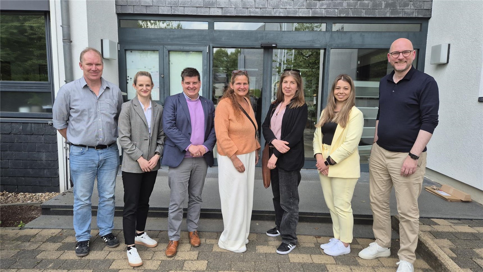 Gruppenfoto vor dem Rathaus : Zum gemeinsamen Pressetermin erschienen die abgebildeten Partner v.l.n.r.: Christof Puchner (Caritas-Mitarbeiter Migrationshilfe), Lena Winter (stellv. Fachbereichsleitung Soziale Arbeit, Caritas), Oliver Krings (Vorstand Caritas), Alexandra Budde-Karner (Flüchtlingsrat), Monika von Bernuth (Flüchtlingsrat), Jana Förster (Fachbereichsleitung Soziales, Gemeinde Roetgen), Jorma Klauss (Bürgermeister Roetgen). 